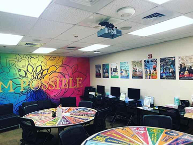 Inside of WorkStartYes's resource room, which has a large colorful mural on the wall.